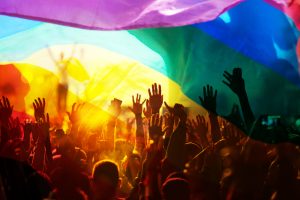 peaceful PRIDE rally hands in air rainbow flag